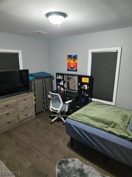 bedroom with dark hardwood / wood-style flooring