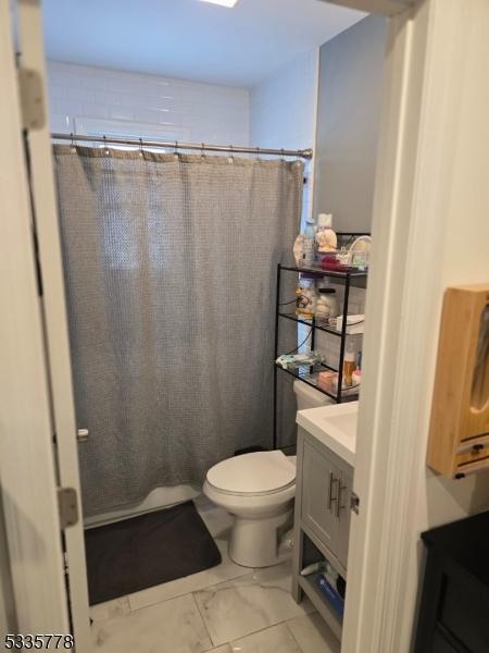 bathroom with vanity, toilet, and curtained shower