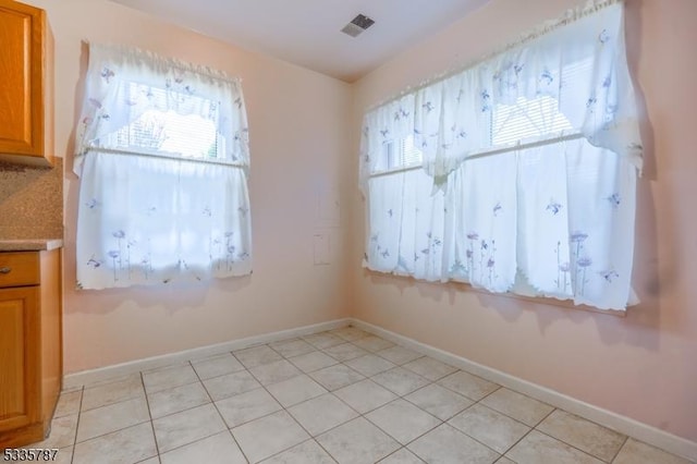 unfurnished room with visible vents, baseboards, and light tile patterned floors