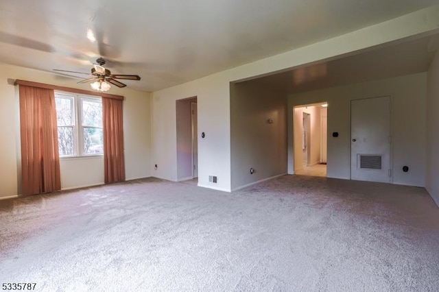 carpeted empty room with a ceiling fan, baseboards, and visible vents