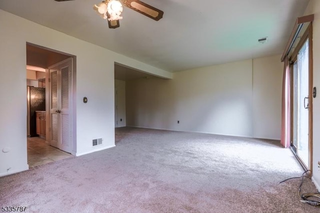 spare room with visible vents, carpet flooring, plenty of natural light, and ceiling fan