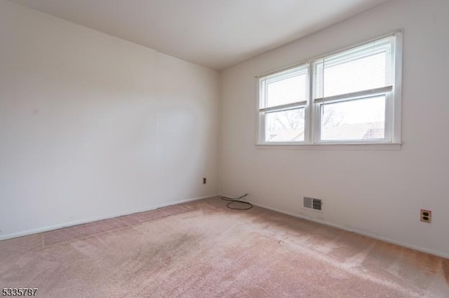 empty room featuring carpet flooring, baseboards, and visible vents