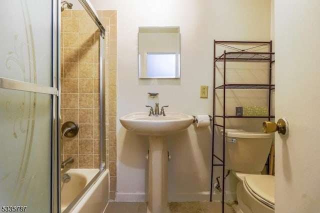 bathroom with shower / tub combination, baseboards, and toilet