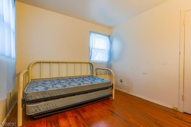 bedroom with baseboards and wood finished floors