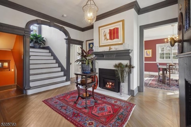 interior space featuring a notable chandelier, hardwood / wood-style flooring, and ornamental molding