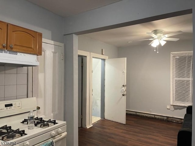 kitchen featuring dark hardwood / wood-style floors, white gas range oven, and ceiling fan