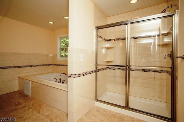 bathroom featuring a bath, recessed lighting, a stall shower, and tile walls