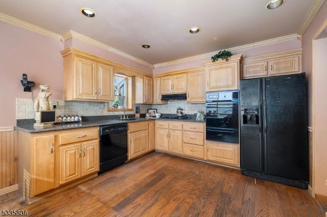 kitchen with dark countertops, ornamental molding, dark wood-style flooring, under cabinet range hood, and black appliances