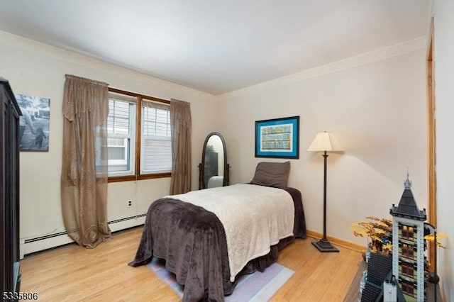 bedroom featuring light wood finished floors, baseboards, ornamental molding, and baseboard heating