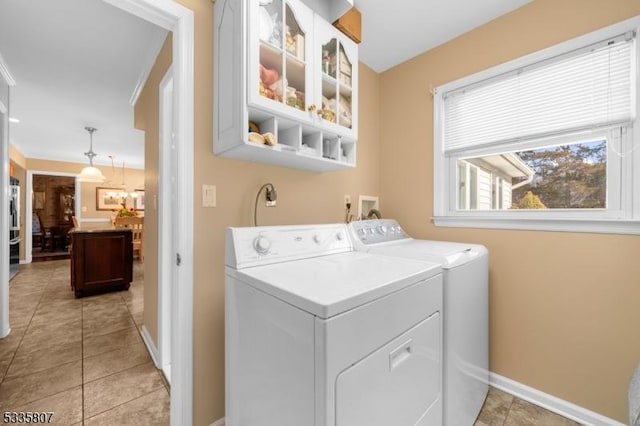 washroom with washer and clothes dryer and light tile patterned floors