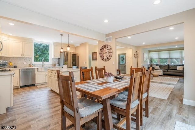 dining room featuring sink and light hardwood / wood-style flooring