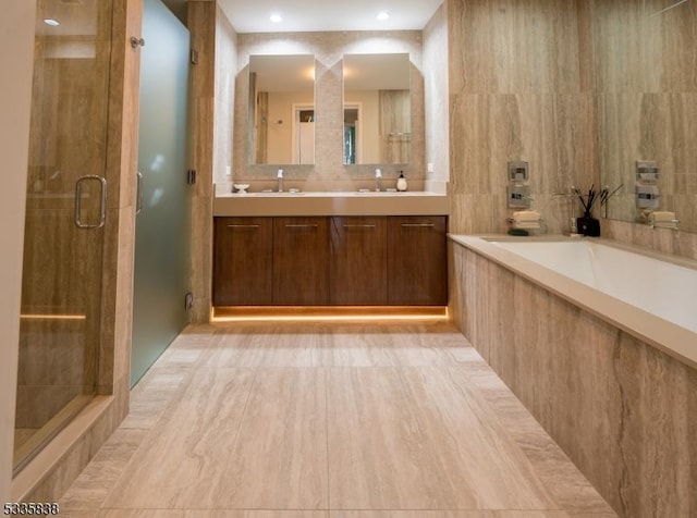 bathroom with plus walk in shower, tile walls, and vanity