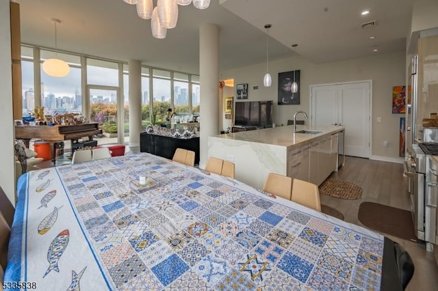 dining space featuring sink, a wall of windows, and hardwood / wood-style floors