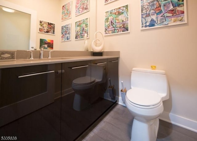 bathroom with vanity, wood-type flooring, and toilet