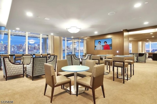 carpeted dining room with a wall of windows