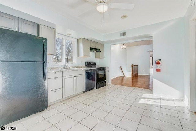 kitchen featuring light tile patterned flooring, sink, gray cabinetry, and black appliances