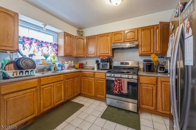 kitchen with stainless steel appliances, sink, and light tile patterned floors