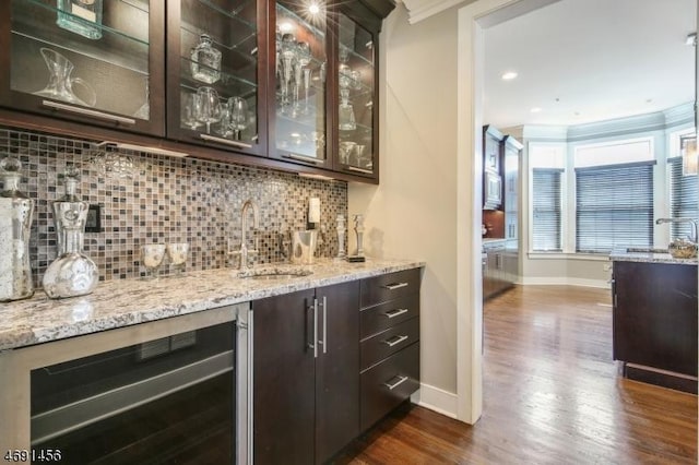 bar featuring sink, dark brown cabinets, wine cooler, tasteful backsplash, and dark hardwood / wood-style flooring