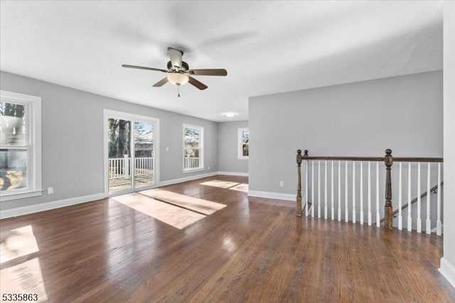 empty room featuring dark wood-style flooring, ceiling fan, and baseboards