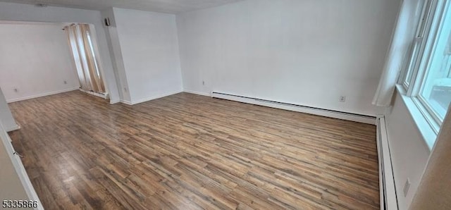 unfurnished room with a baseboard radiator and wood-type flooring