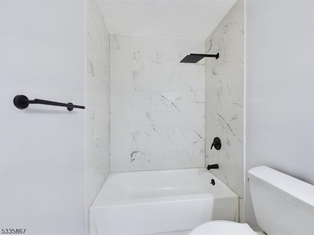 bathroom with tiled shower / bath, toilet, and a textured ceiling