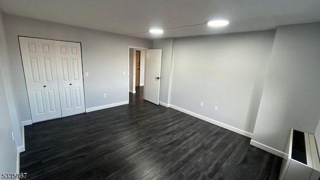 unfurnished bedroom featuring dark hardwood / wood-style floors and a closet