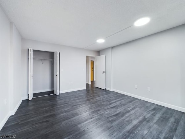 unfurnished bedroom featuring dark hardwood / wood-style flooring and a closet