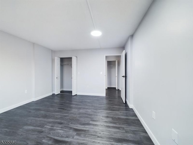 unfurnished bedroom with dark hardwood / wood-style floors and a closet