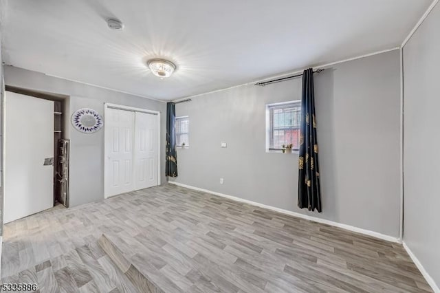 unfurnished bedroom with light hardwood / wood-style flooring and a closet