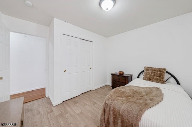 bedroom with light hardwood / wood-style flooring and a closet