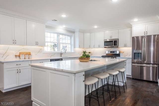 kitchen with white cabinetry, dark hardwood / wood-style floors, stainless steel appliances, and a center island