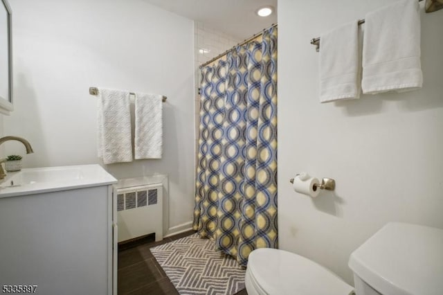 bathroom with radiator heating unit, toilet, curtained shower, and vanity