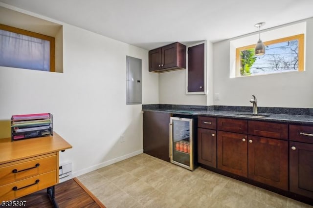 kitchen featuring wine cooler, decorative light fixtures, electric panel, and sink