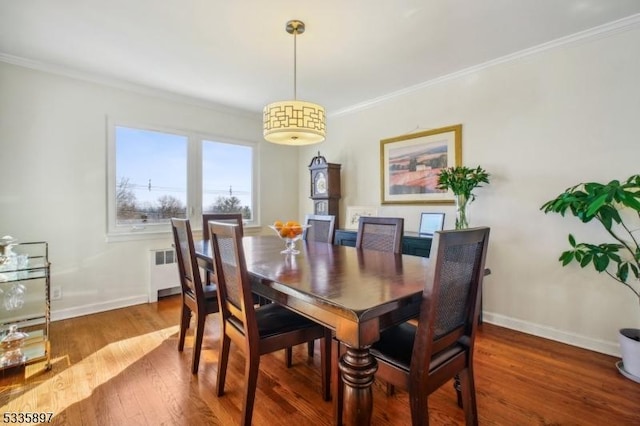 dining area with ornamental molding, radiator, and hardwood / wood-style floors