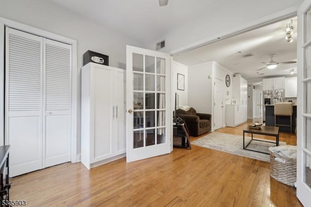 living room featuring french doors, ceiling fan, and light hardwood / wood-style floors