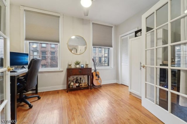 office with french doors and light hardwood / wood-style flooring