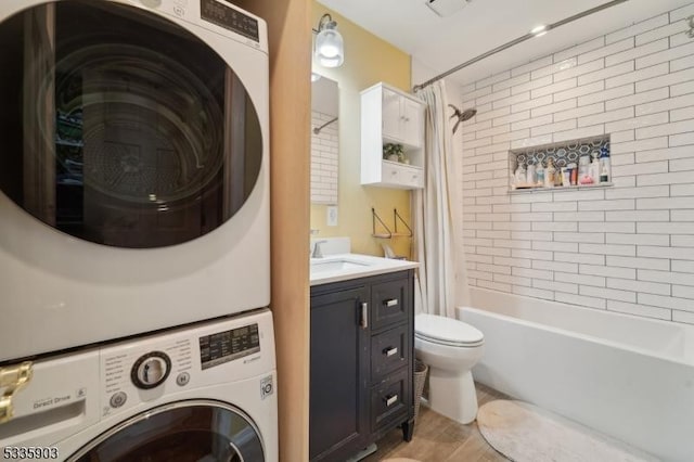 laundry area featuring sink, light wood-type flooring, and stacked washing maching and dryer