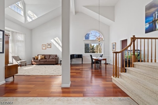 interior space featuring baseboards, stairway, an inviting chandelier, and wood finished floors