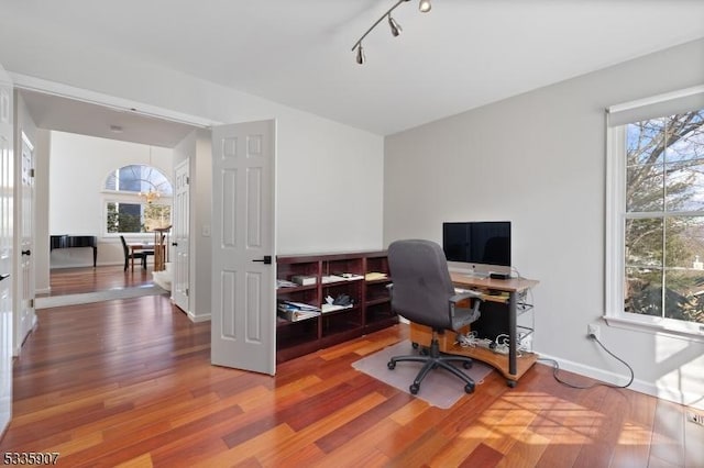 office space with track lighting, baseboards, and wood finished floors