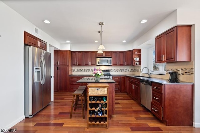 kitchen with stainless steel appliances, dark countertops, a sink, and open shelves