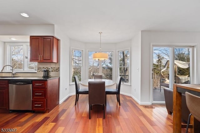 dining room with plenty of natural light, baseboards, and wood finished floors