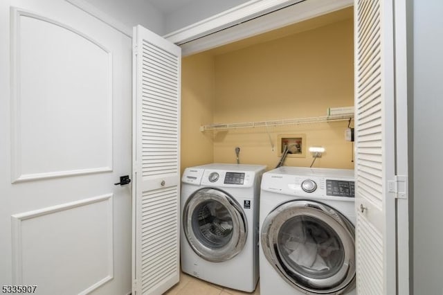 laundry area featuring laundry area, independent washer and dryer, and light tile patterned floors