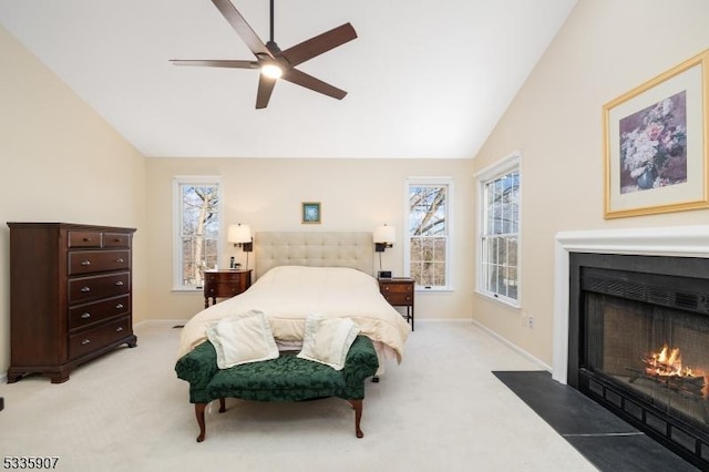 bedroom with lofted ceiling, light colored carpet, a fireplace with flush hearth, a ceiling fan, and baseboards