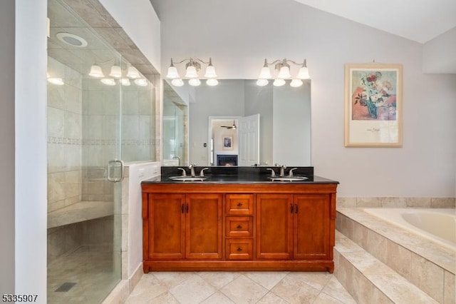 full bathroom with lofted ceiling, a shower stall, double vanity, and a sink