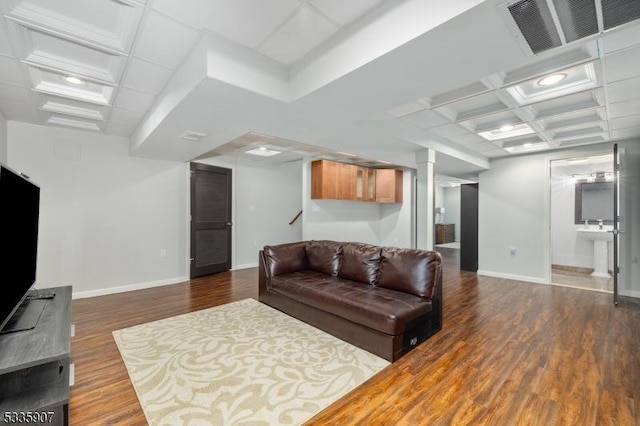 living room featuring coffered ceiling, visible vents, baseboards, beam ceiling, and dark wood finished floors