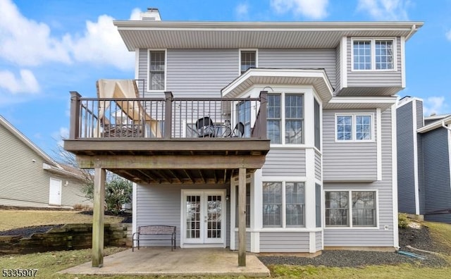 back of house with french doors, a patio area, and a balcony