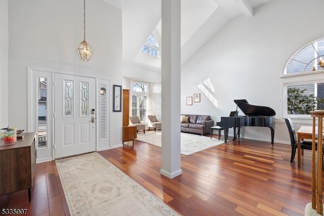 foyer entrance with dark wood-style floors and high vaulted ceiling