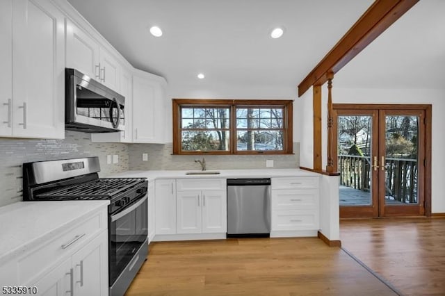 kitchen featuring tasteful backsplash, sink, stainless steel appliances, and white cabinets