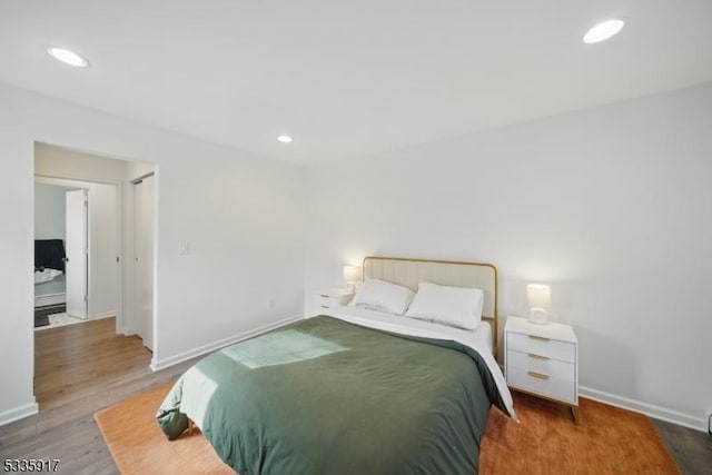 bedroom featuring baseboards, wood finished floors, and recessed lighting