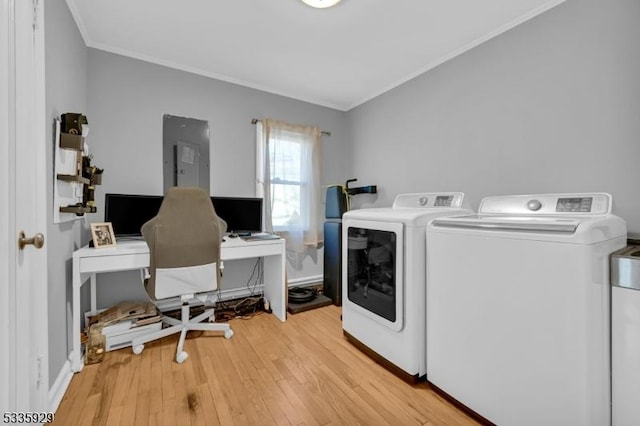 washroom featuring ornamental molding, electric panel, independent washer and dryer, and light hardwood / wood-style flooring